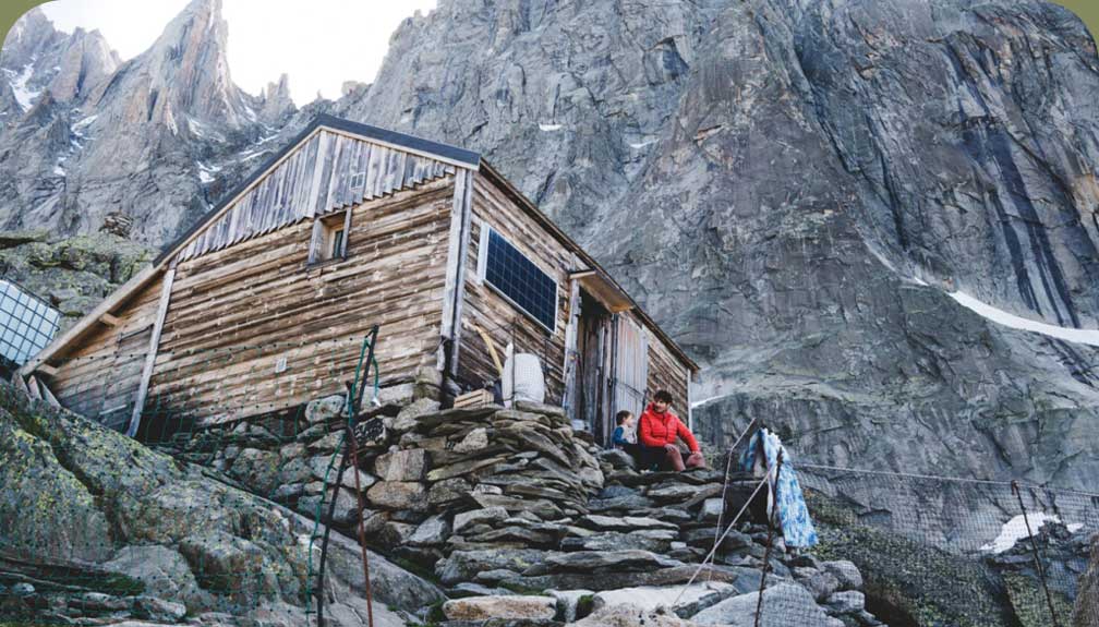 A person and child sitting in a structure high in the mountains.