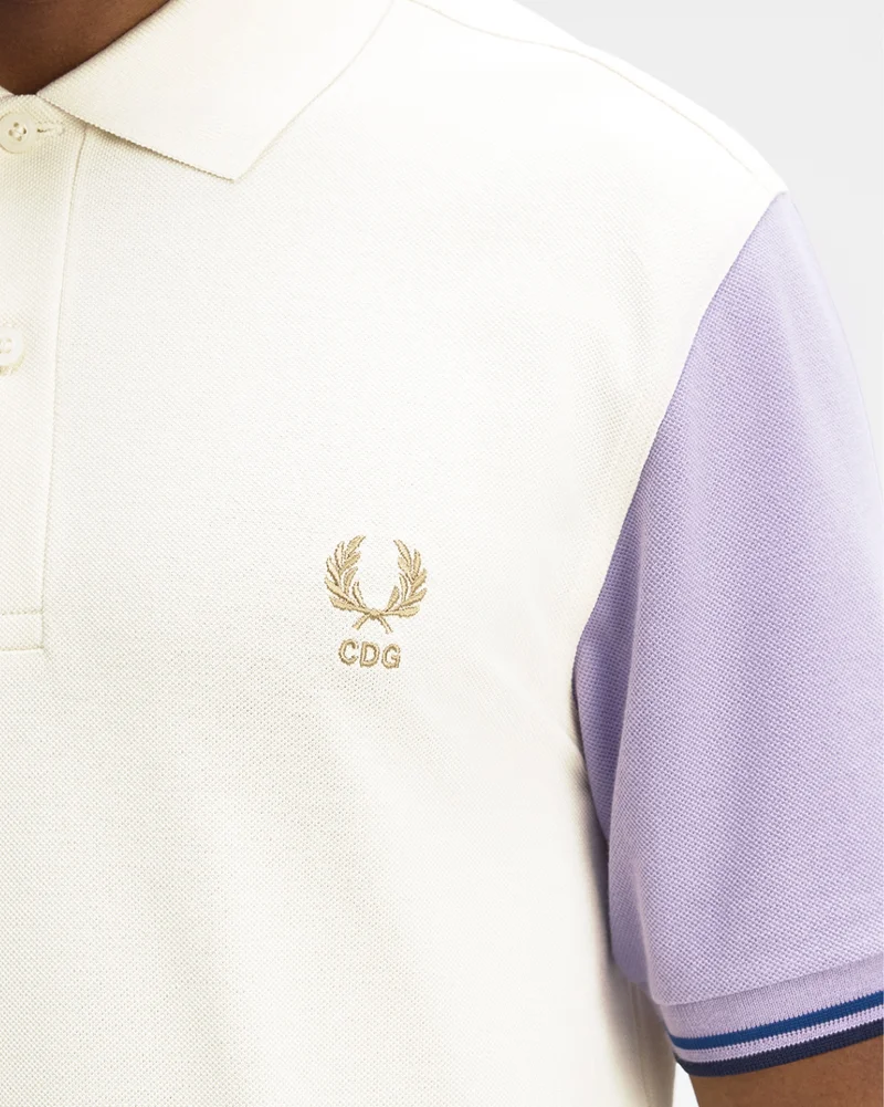 A close up shot of a model wearing a Fred Perry x Comme des Garçons SHIRT