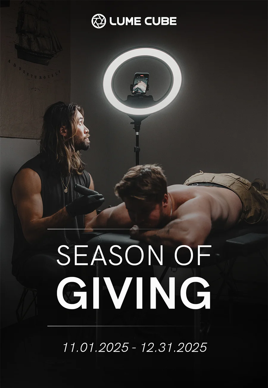Tattoo artist working under Lume Cube Ring Light Pro. Text reads ‘Season of Giving, 11.01.2025 – 12.31.2025.'