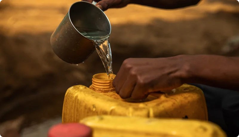 A person filling a jerry can with water.