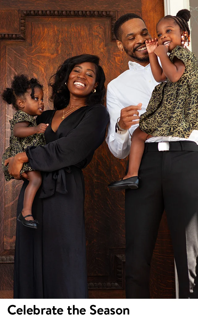 A woman in a black dress, a man in a white shirt and black slacks and two little girls in gold-print dresses.