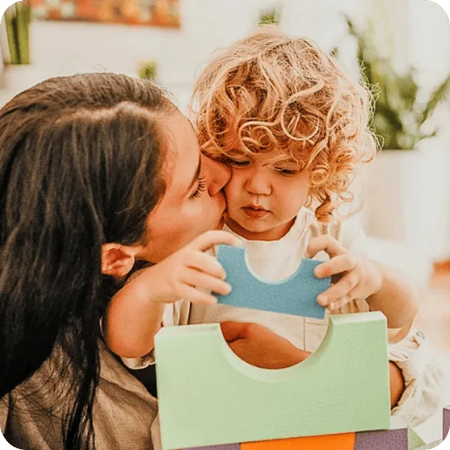 a mom playing blocks with her toddler and not worrying about developmental milestones a mom playing blocks with her toddler and not worrying about developmental milestones