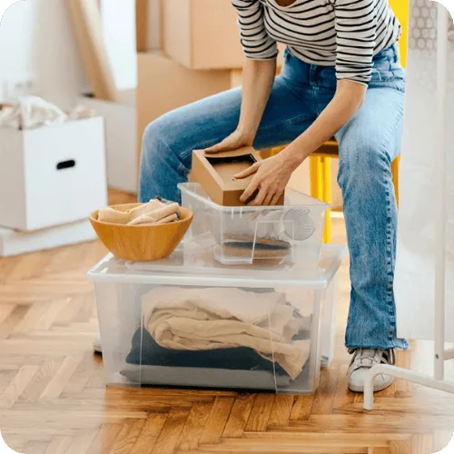 a woman organizing boxes and bins in a house a woman organizing boxes and bins in a house