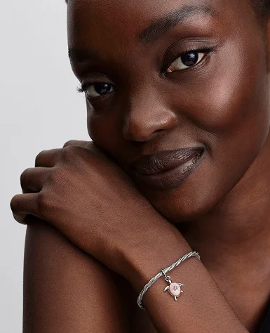The turtle charm styled on a snake chain bracelet