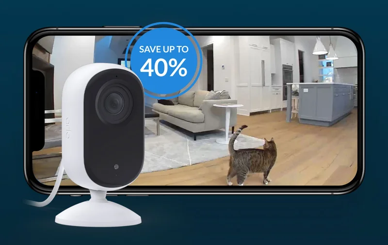 Up to 40% off. Essential 2K Indoor Camera next to a phone with a simulated Arlo screen image showing a point-of-view image of a cat inside a house.