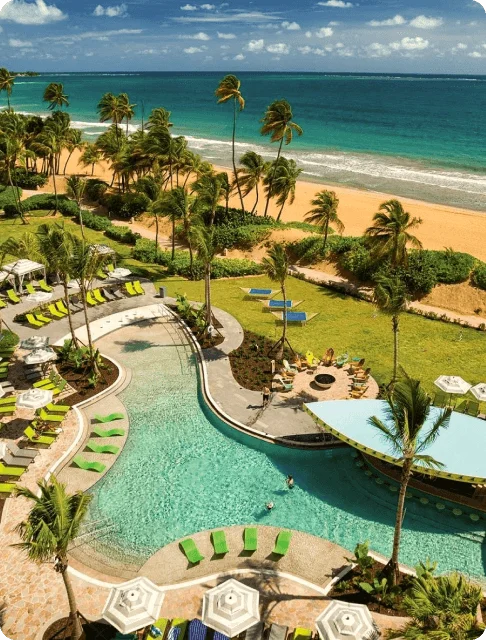 Image Description: Aerial view of a beachfront pool with a swim-up bar in Puerto Rico’s Margaritaville Vacation Club At Wyndham Rio Mar