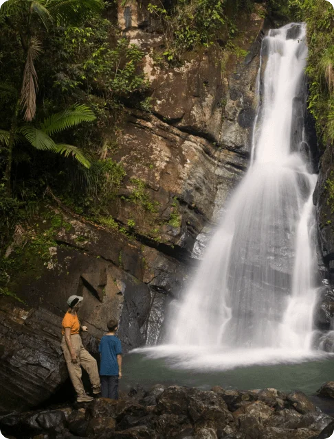 Image Description: A mother and son admiring Cascada La Mina, a popular waterfall in El Yunque National Forest