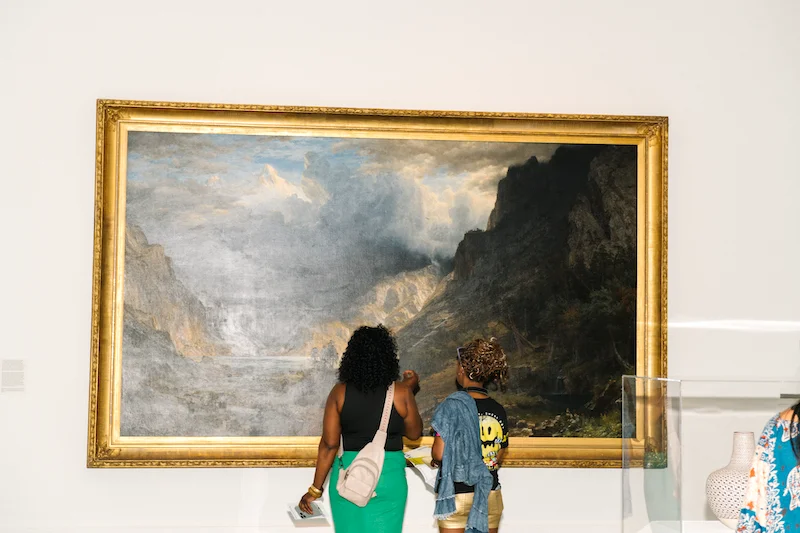 A photograph of two people looking at art