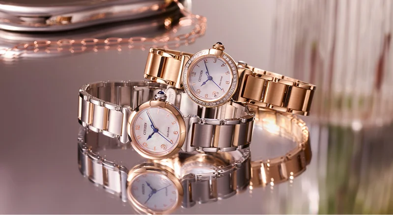 Close up of two women's Citizen L watches stacked on a glass tabletop