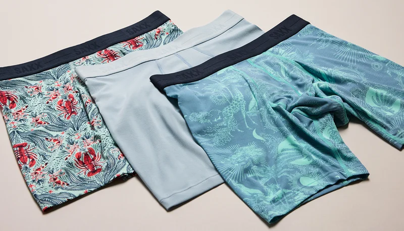 Three pairs of SAXX boxer briefs in solid and patterned styles laid flat