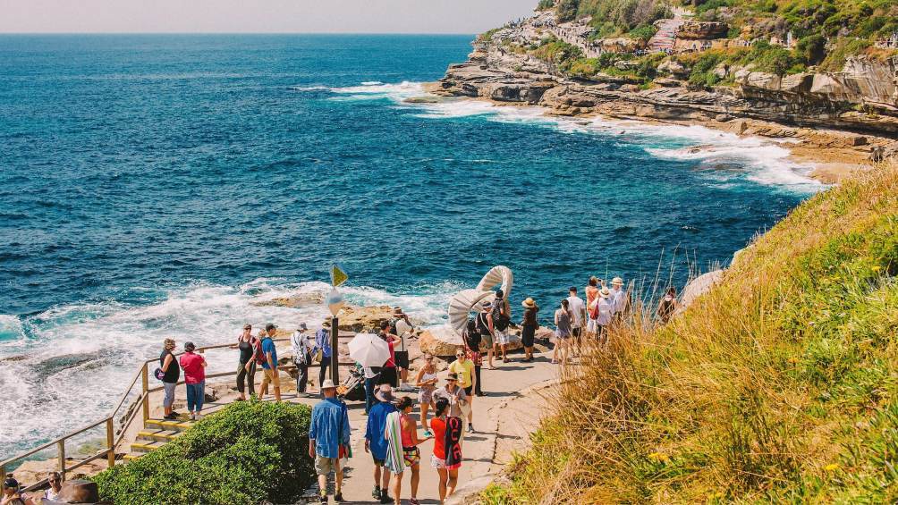 Image description: People walking on a path in Bondi, Australia.