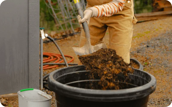 Photo of a person shoveling compost