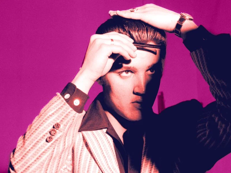 Image may contain: Elvis Presley, Face, Head, Person, Photography, Portrait, Body Part, Finger, Hand, Adult, and Wristwatch