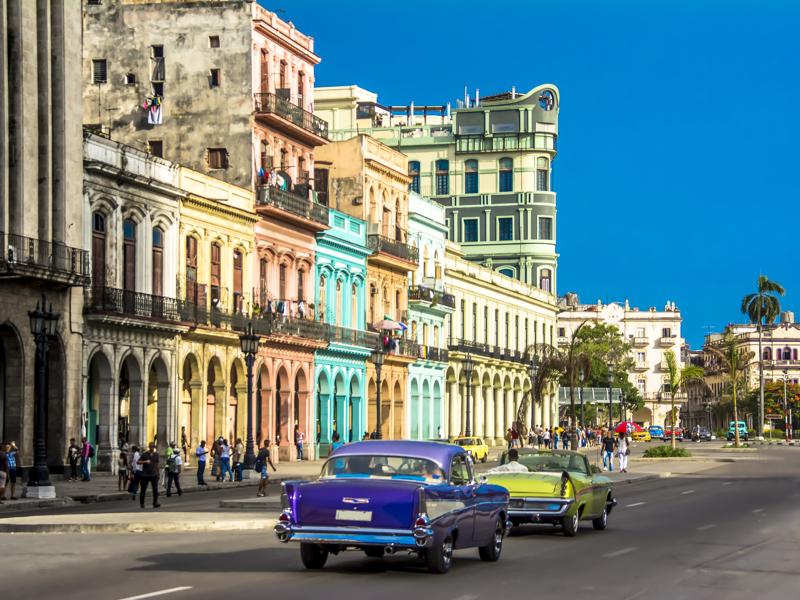 View of downtown Havana city with old classic cars and people walking on the street, Cuba.