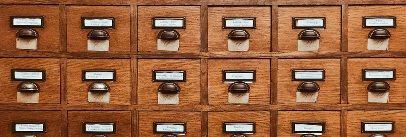 A wooden filing cabinet with numbered drawers.