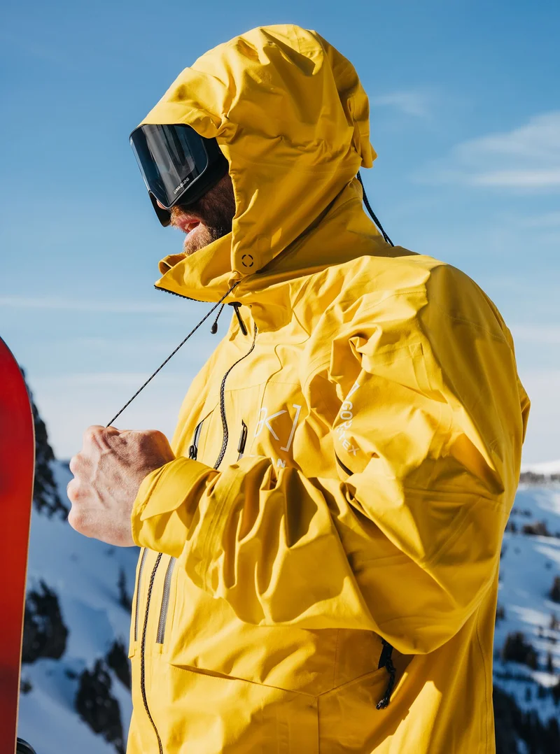 Men's Burton [ak] Hover GORE‑TEX 3L Stretch Jacket in yellow in the mountains and a blue sky in the background