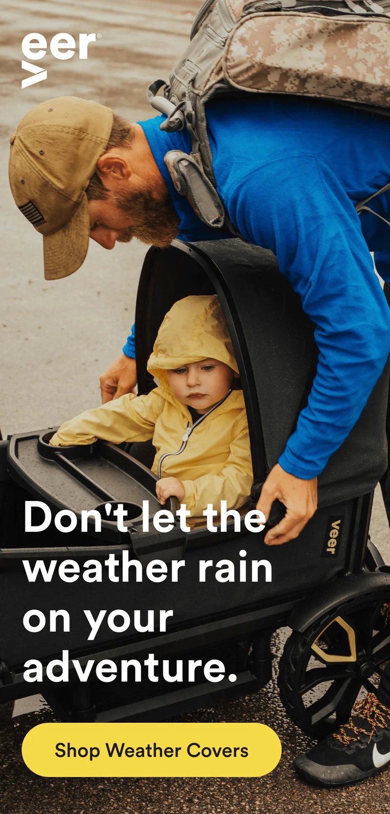 a man sets a veer cruiser canopy for his child to shield from the rain