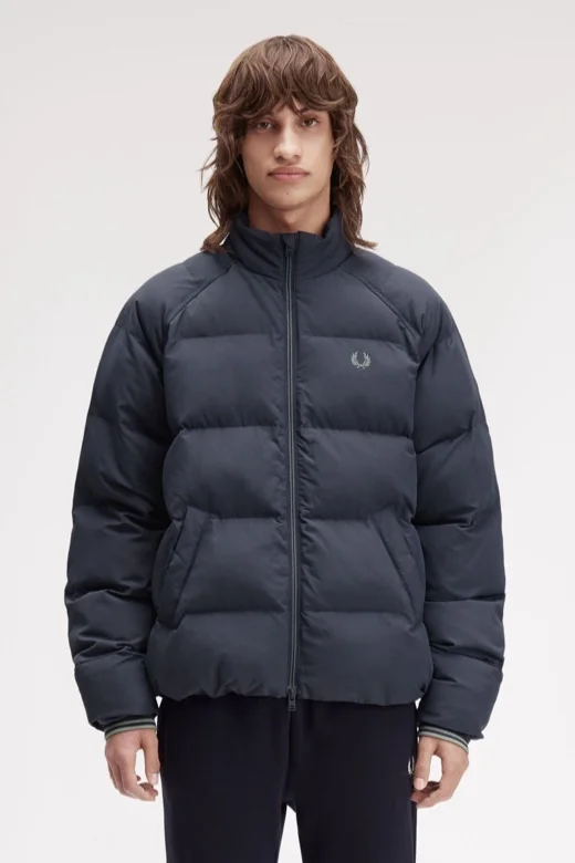 Male model wearing a Fred Perry Raglan Sleeve Padded Jacket in Dark Airforce