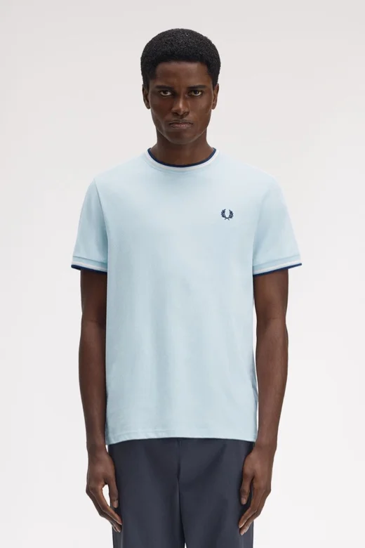Male model wearing a Fred Perry Twin Tipped T-Shirt in Light Ice / Silky Peach / Tennis Blue
