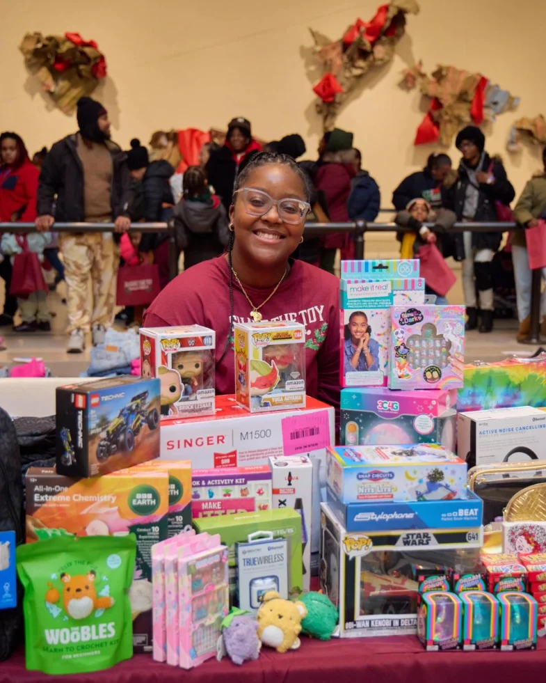 A person sitting behind a pile of toys