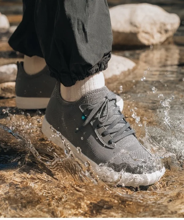 Graphic of someone stepping in a stream wearing their Weekend Sneakers in Concrete Grey.