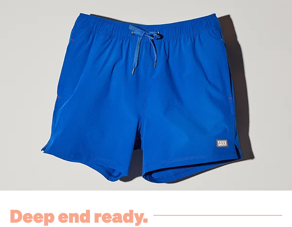 Cobalt blue SAXX swim shorts against a light grey background with "Deep end ready" text.