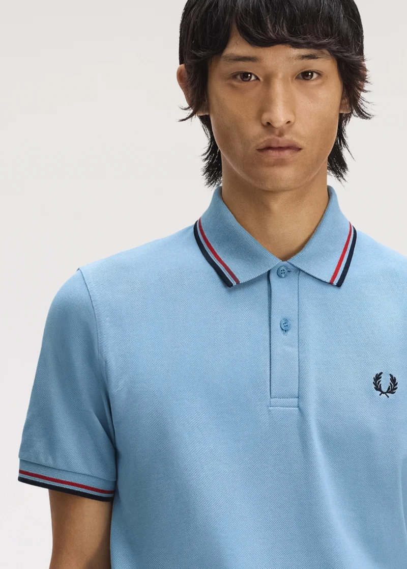 Male model wearing a M12 Fred Perry Shirt in Sky / Red / Navy