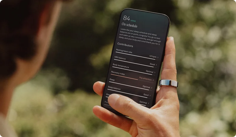 Person wearng Oura Ring holding phone
