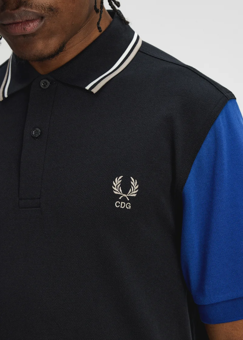 Fred Perry x Comme des Garçons Shirt - the second drop of our latest collection; the image shows a polo shirt with a black base and colour block sleeves