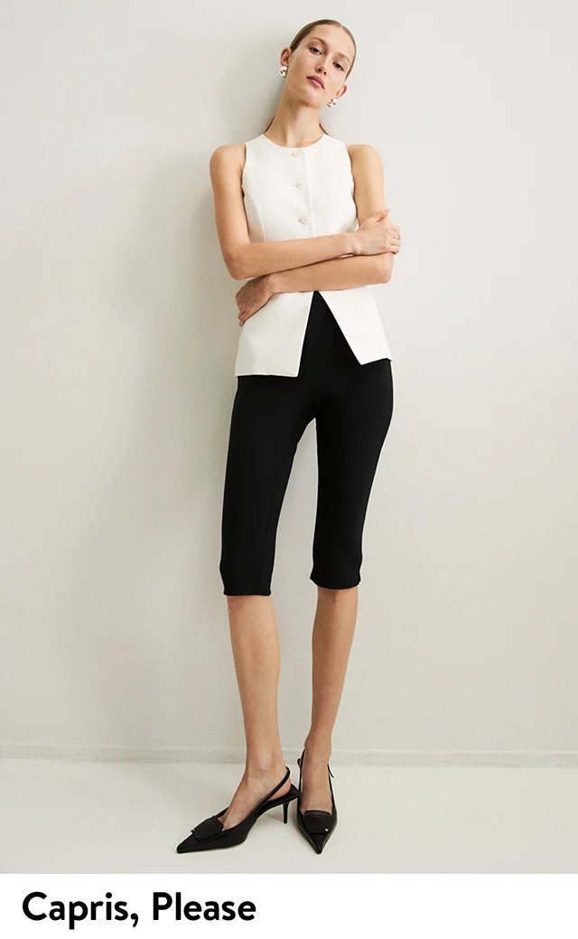 A woman wearing a white sleeveless top with black capri pants.