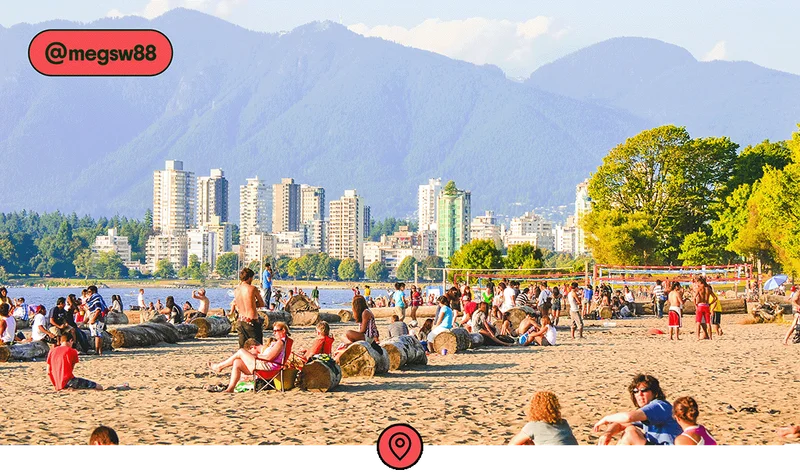 Image description: People sitting, walking, and playing volleyball on a beach along the Vancouver harbor, photo taken by @megsw88