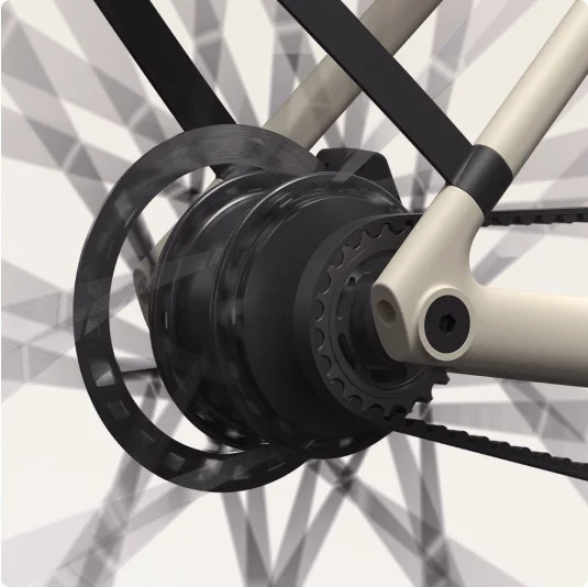 Close-up of the rear hub and belt drive system on a sand-coloured Cowboy bike, highlighting the drivetrain components.