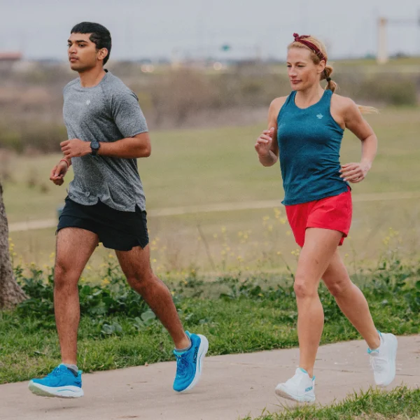 Man and woman wearing HOKA shoes