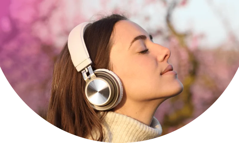 Woman with eyes closed listening to Calm through wireless headphone