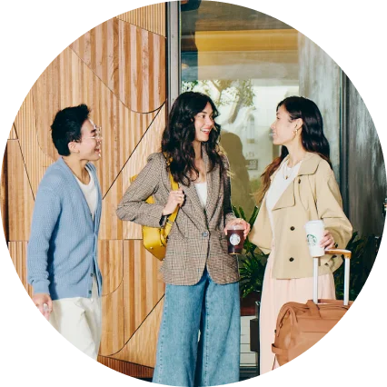 Three travelers meet up in a Marriott hotel lobby, one holding a Starbucks coffee.