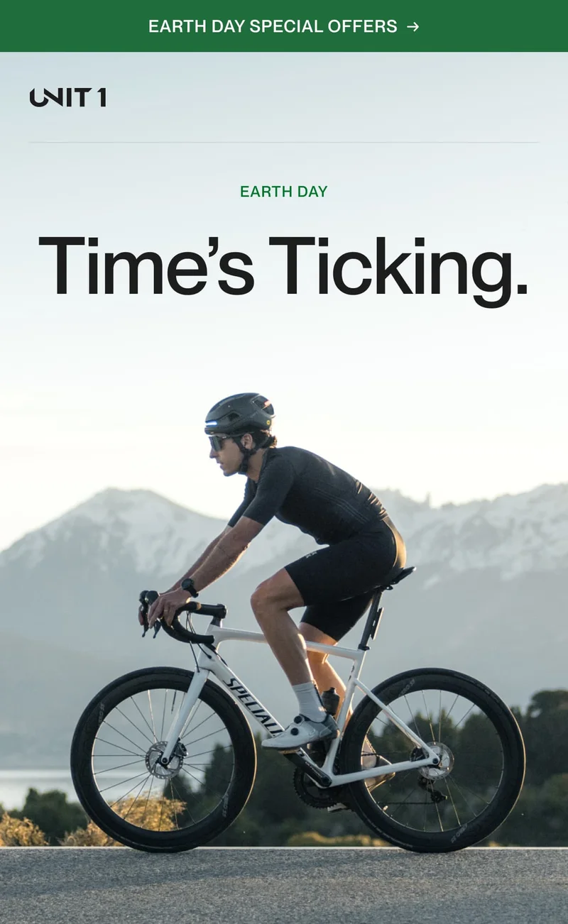 Cyclist wearing a UNIT 1 smart helmet rides a road bike at dawn with mountains in the background—highlighting Earth Day’s call to ride smarter.