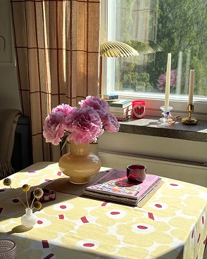 Unikko table cloth with an Umpu and flower vase on top of it. Unikko table cloth with an Umpu and flower vase on top of it.