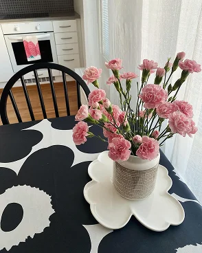 Flower vase on table set with Unikko table cloth. Flower vase on table set with Unikko table cloth.