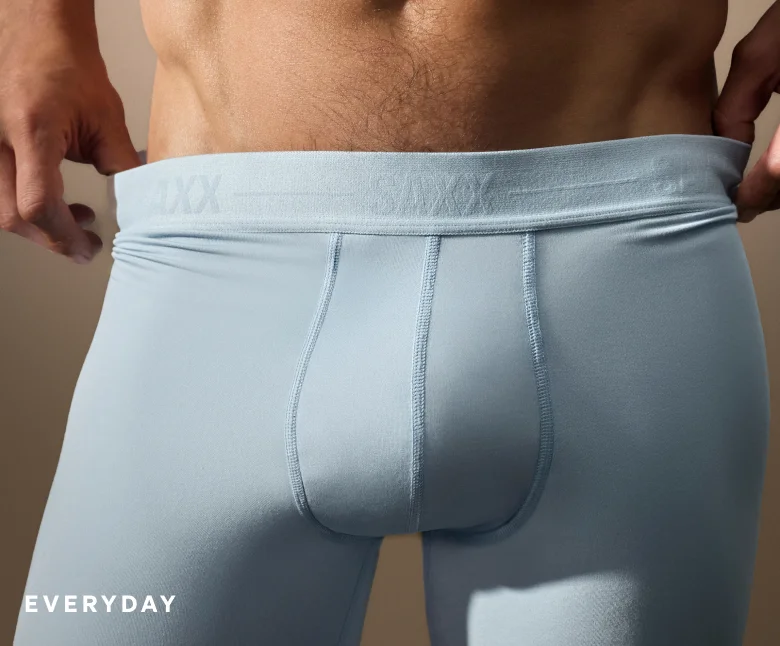 Model wearing light blue SAXX Smooth Luxe boxer brief with soft stretch fit, labeled Everyday.