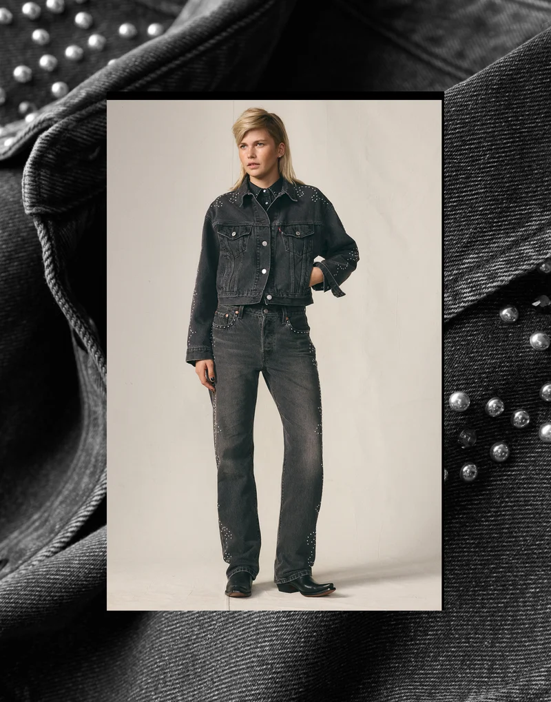 Person wearing a black trucker jacket and black jeans.