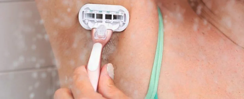 Woman shaving her armpits