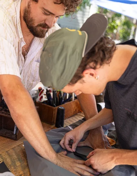 two people working together to fix a garment.