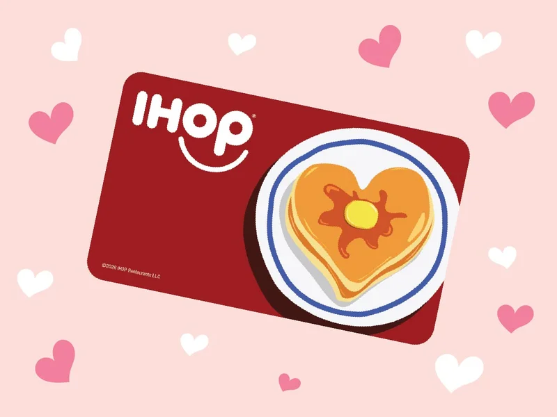 An IHOP Gift card with illustrated pancakes in the shape of a heart is against a pink background with illustrated white and pink hearts.