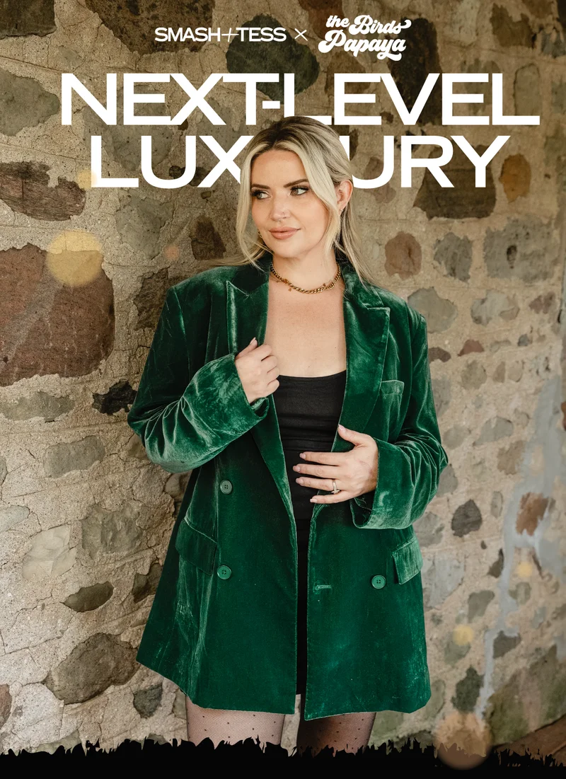 sarah landry wearing green velvet blazer in front of brick wall with text 'next-level luxury'