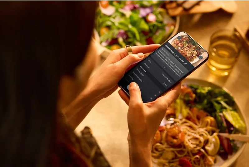 Person wearing Oura Ring taking a picture of their meal with the Oura app