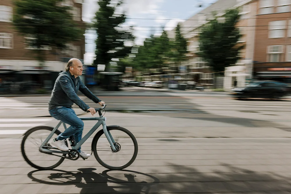 A man riding on an electronic-bike on a road in Amsterdam