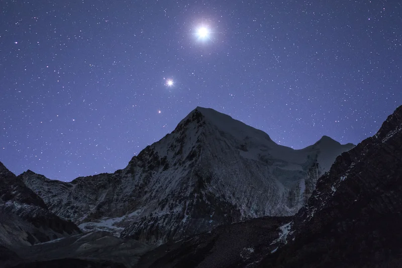 Planets Venus (top), Jupiter (middle), and Mars (bottom) rise above a mountain peak at Yading reserve in China, 2015.