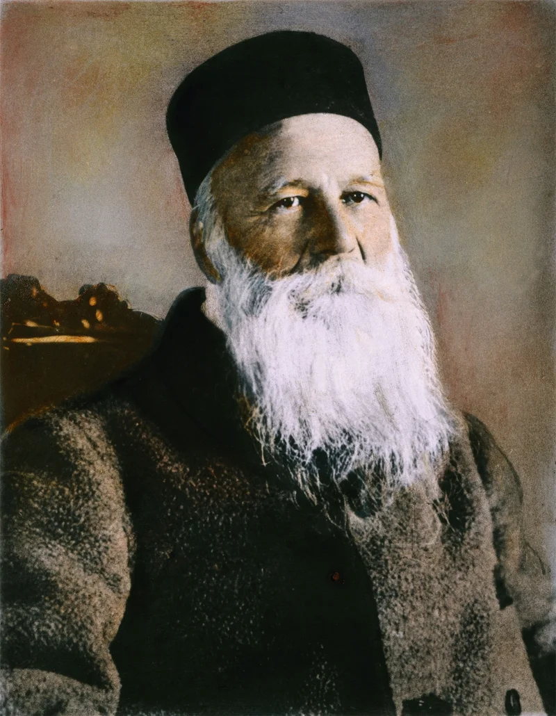 A colorized photo of Dunant with his white beard and black hat