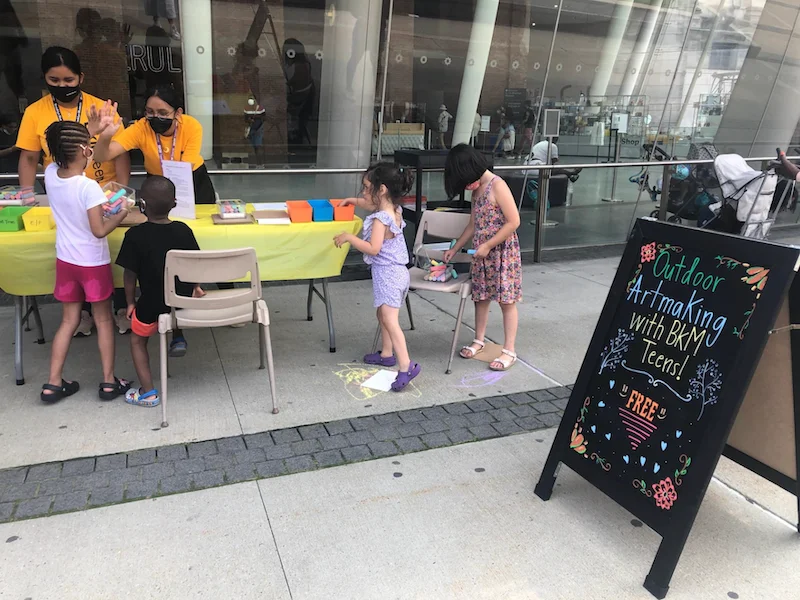 Four children standing at a table making art
