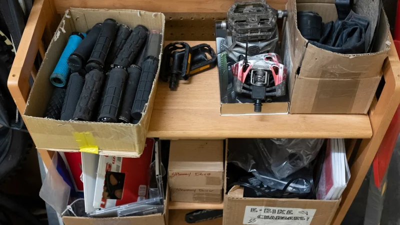 A shelf holding boxes of spare bike parts.